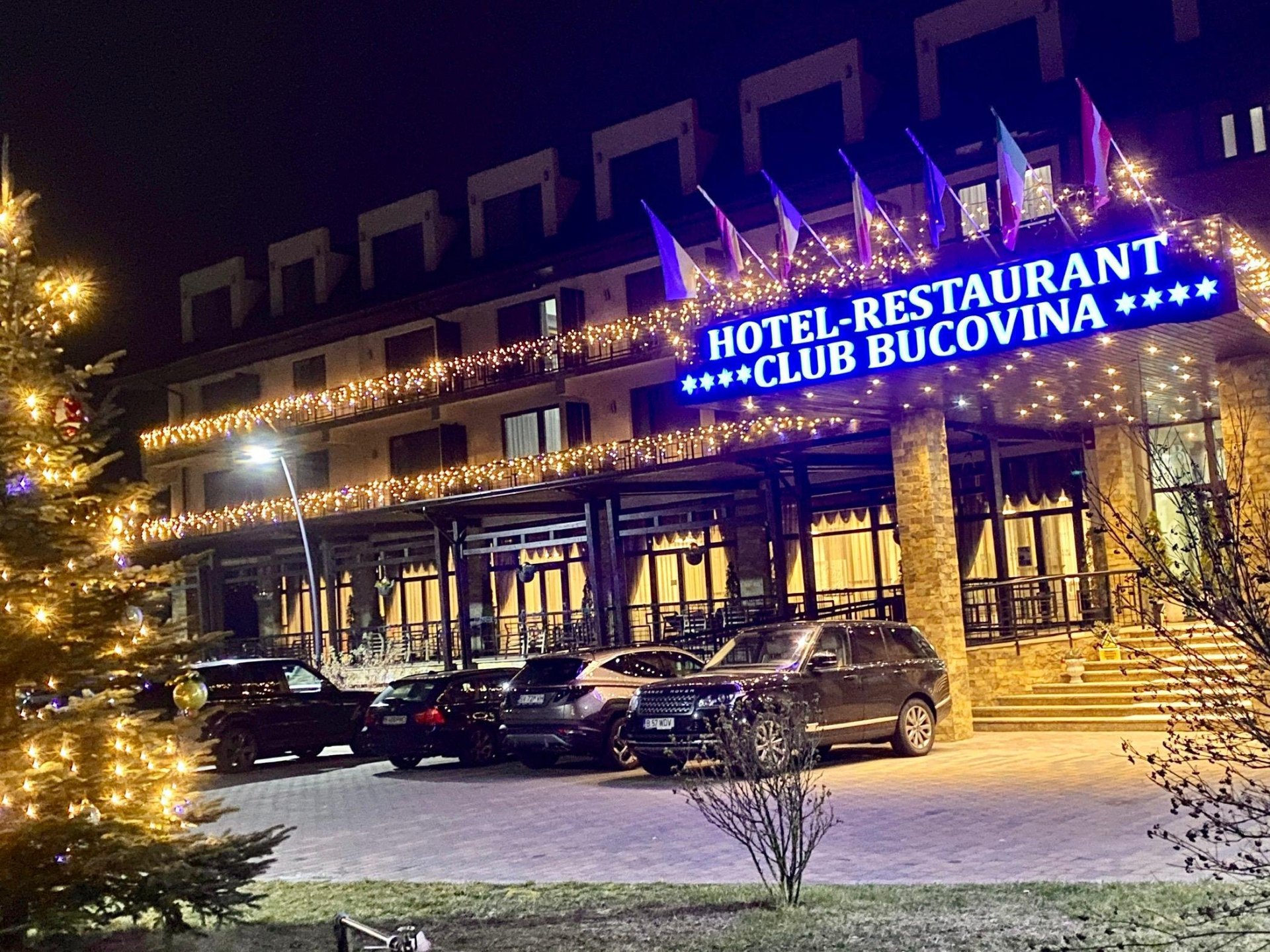 Fațada Club Bucovina cu iluminare festivă seara